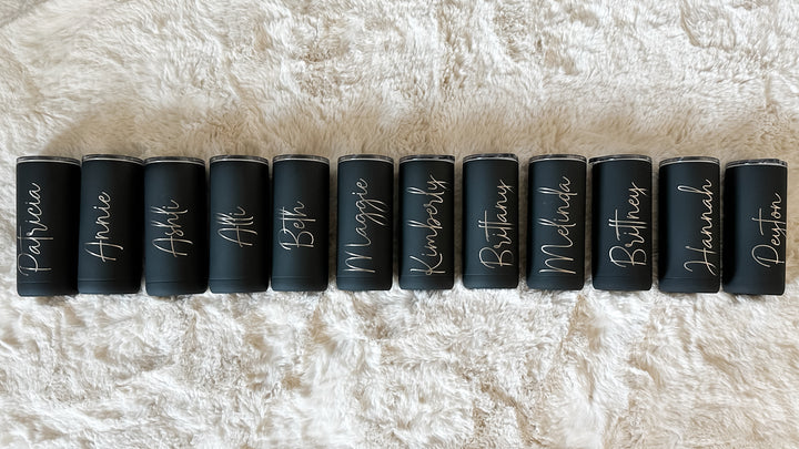 A dozen matte black 16oz screw-top tumblers with various names engraved.
