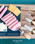 Acacia wood charcuterie board with slate serving surface and three wood-handled serving utensils. Engraved in the style of a dictionary entry stating "Charcuterie a french term for assembling cheese and other fancy shit." Engraved and sold by Like No Otter Design Co.